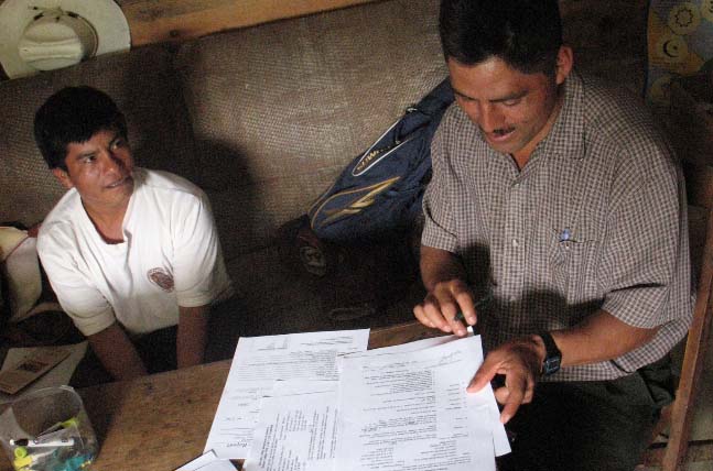 Former President of the Producer Board of Directors, Jose Arias signs contracts during an annual CoopCoffees visit to meet with Maya Vinic farmer members in Acteal.